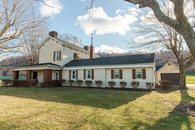 view of front of property with an outbuilding, a front lawn, and a garage