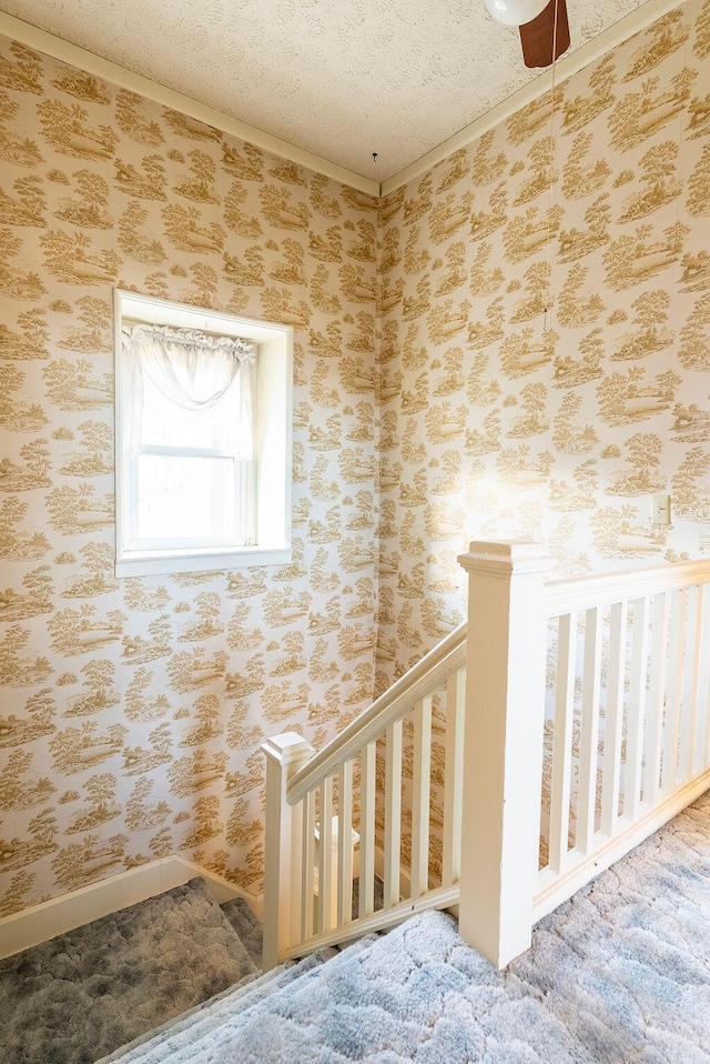 stairway with carpet flooring, a textured ceiling, and ornamental molding