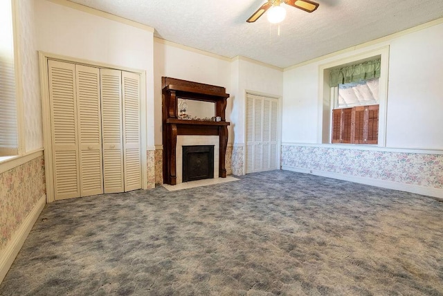 unfurnished living room featuring ceiling fan, carpet, and a textured ceiling