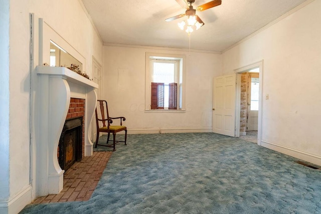 living area featuring carpet flooring, ceiling fan, a fireplace, and ornamental molding