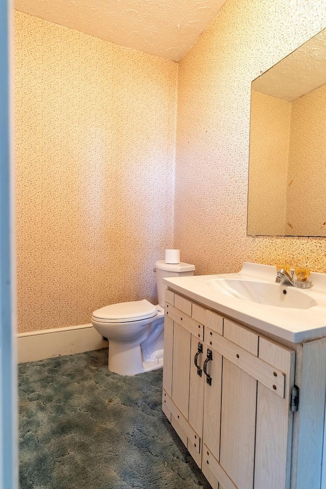 bathroom featuring a textured ceiling, vanity, and toilet