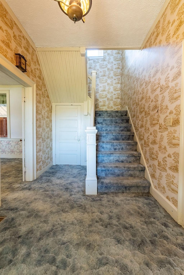 stairs with carpet flooring and a textured ceiling