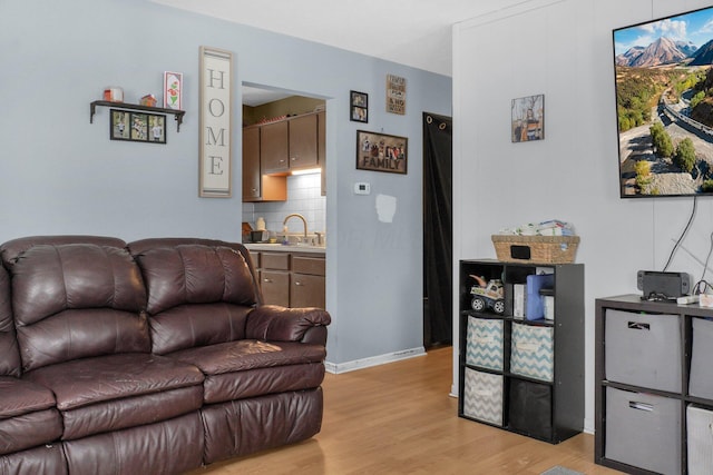 living room featuring light wood-type flooring and sink