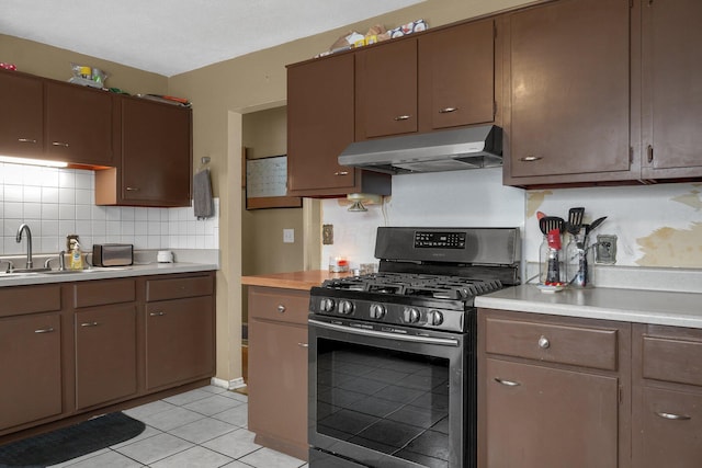 kitchen with light tile patterned flooring, stainless steel range with gas cooktop, and sink