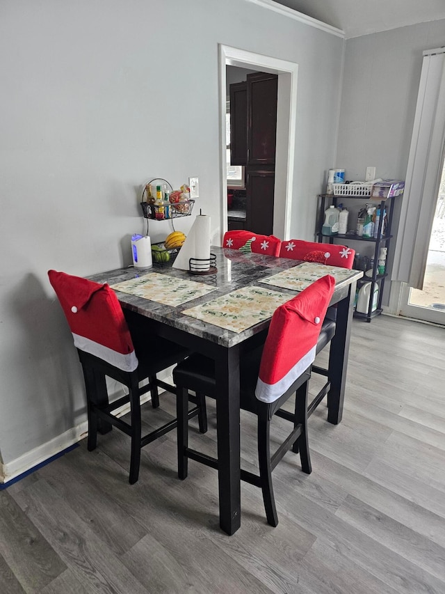 dining room with wood-type flooring and ornamental molding