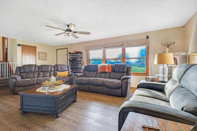 living room with ceiling fan, hardwood / wood-style floors, and a textured ceiling