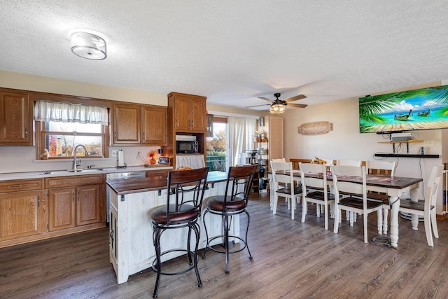 kitchen with a textured ceiling, ceiling fan, a healthy amount of sunlight, and dark hardwood / wood-style floors