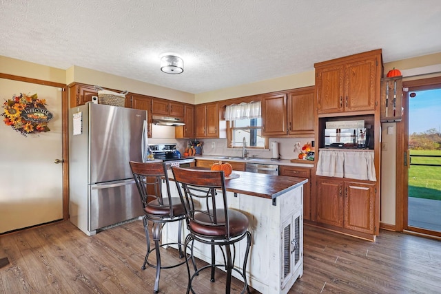 kitchen featuring a kitchen island, wood-type flooring, sink, and appliances with stainless steel finishes