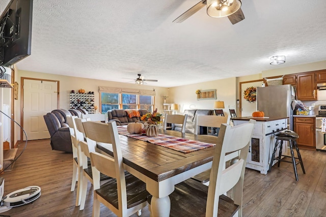 dining space featuring a textured ceiling, ceiling fan, and dark hardwood / wood-style floors