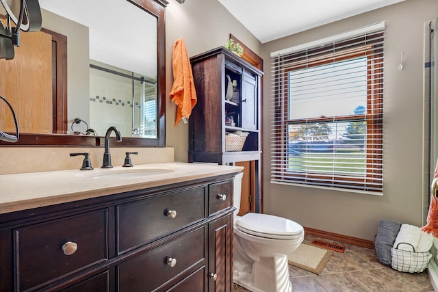 bathroom featuring vanity, toilet, and a healthy amount of sunlight