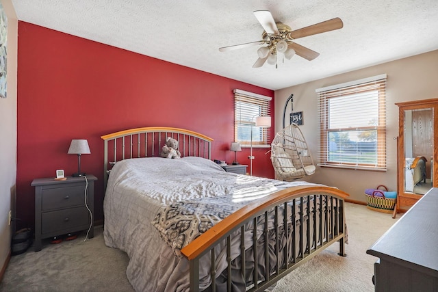 bedroom with carpet flooring, ceiling fan, and a textured ceiling