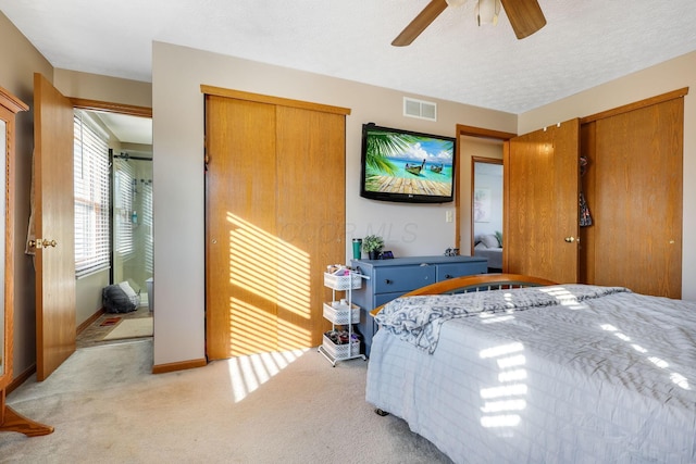 carpeted bedroom with ceiling fan and a textured ceiling