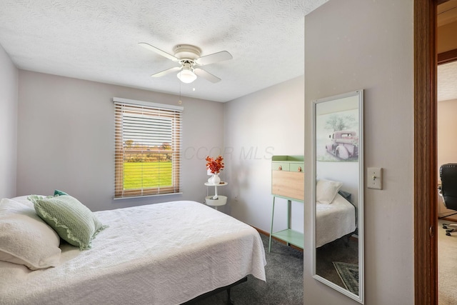 carpeted bedroom with ceiling fan and a textured ceiling