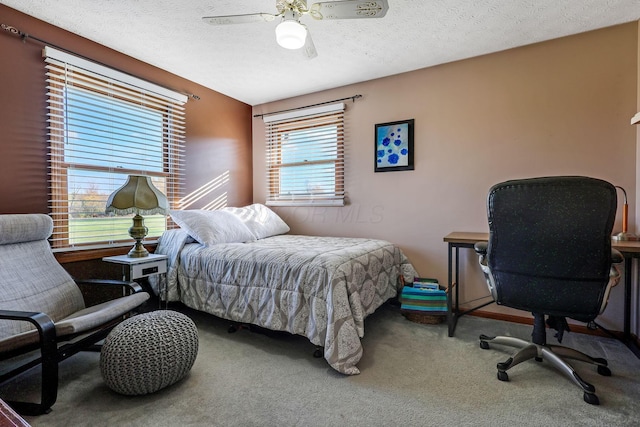 carpeted bedroom with ceiling fan and a textured ceiling