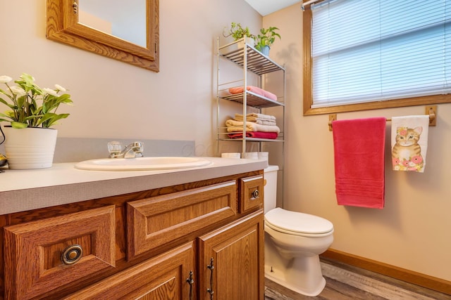 bathroom with hardwood / wood-style floors, vanity, and toilet