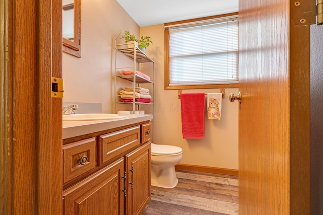 bathroom with hardwood / wood-style floors, vanity, and toilet