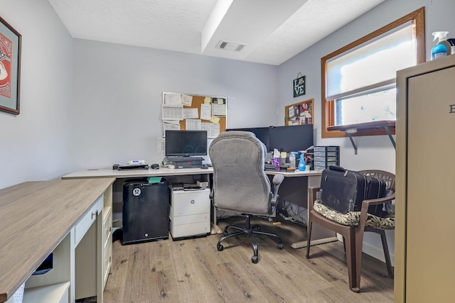 office with a textured ceiling and light hardwood / wood-style flooring