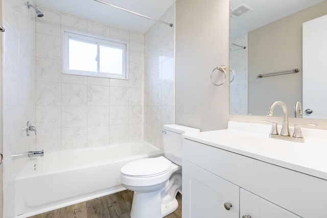 full bathroom featuring tiled shower / bath, toilet, vanity, and hardwood / wood-style flooring