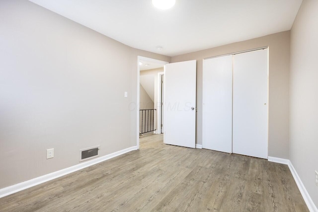 unfurnished bedroom with a closet and light hardwood / wood-style floors