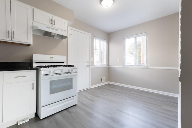 kitchen with white cabinets, white gas stove, and light wood-type flooring