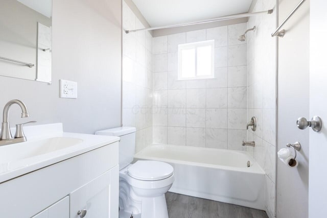 full bathroom featuring toilet, hardwood / wood-style floors, vanity, and tiled shower / bath