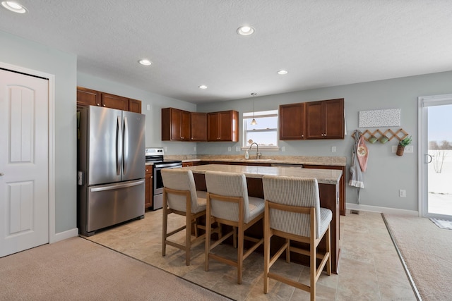 kitchen featuring appliances with stainless steel finishes, sink, a kitchen bar, a center island, and light carpet