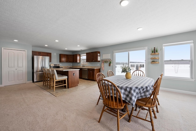 carpeted dining space featuring sink and a textured ceiling