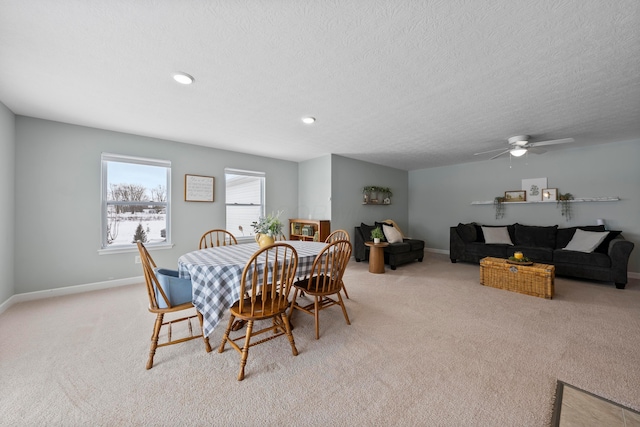 carpeted dining space with ceiling fan and a textured ceiling