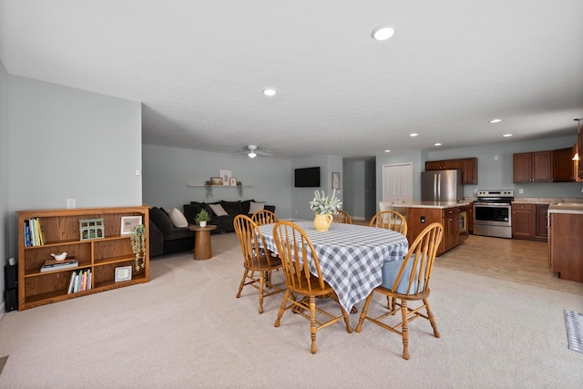 carpeted dining room featuring ceiling fan