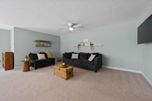 living room with ceiling fan, light colored carpet, and a textured ceiling