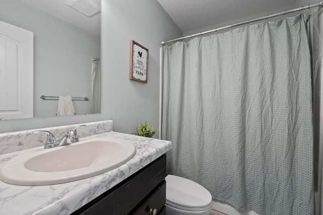 bathroom with a shower with curtain, vanity, a textured ceiling, and toilet