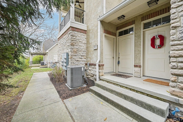 view of exterior entry featuring a balcony and cooling unit