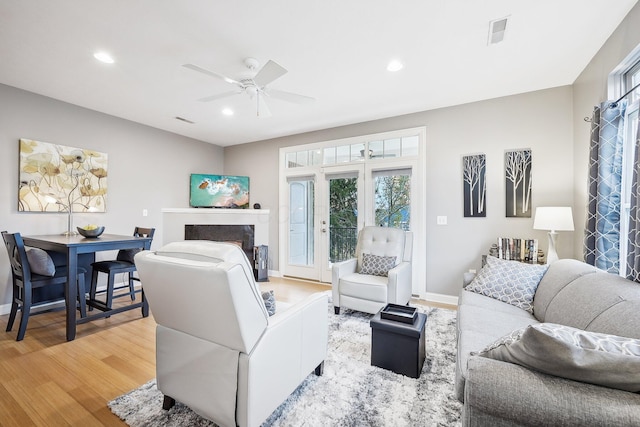 living room with ceiling fan and light hardwood / wood-style flooring