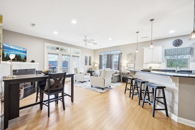 interior space with ceiling fan, a healthy amount of sunlight, and light wood-type flooring