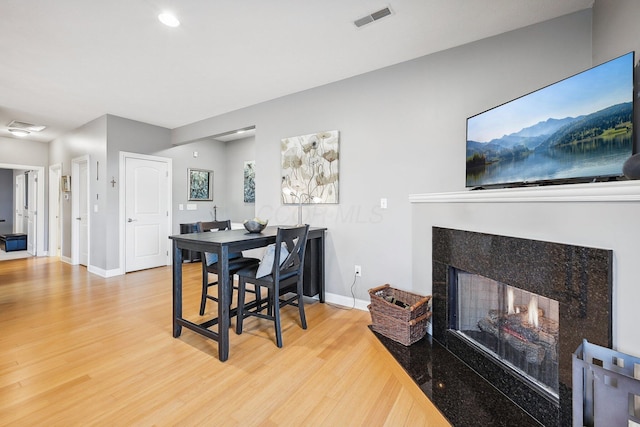 dining space featuring hardwood / wood-style floors and a multi sided fireplace