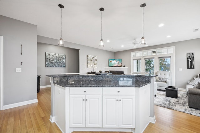 kitchen featuring white cabinetry, ceiling fan, light hardwood / wood-style floors, and hanging light fixtures