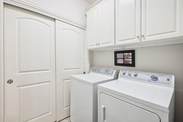 laundry area with cabinets and washing machine and clothes dryer