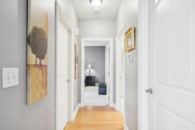 hallway featuring light hardwood / wood-style floors and a textured ceiling