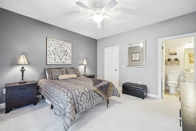 bedroom featuring ceiling fan, light carpet, and ensuite bath