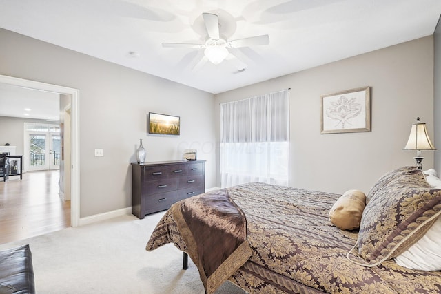 bedroom featuring french doors, ceiling fan, and light colored carpet