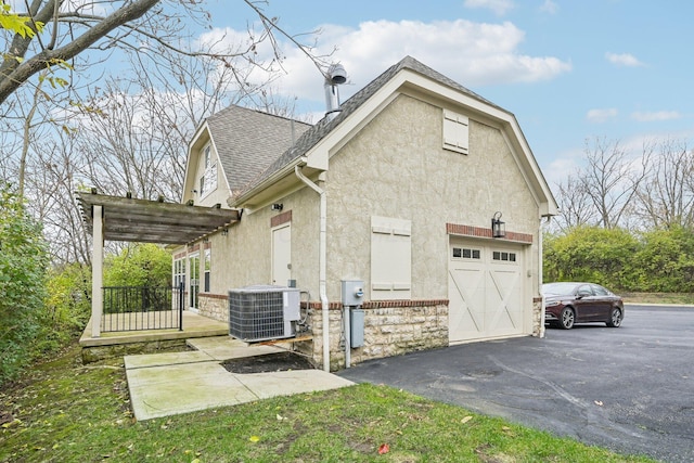 view of side of property featuring a garage and central AC unit