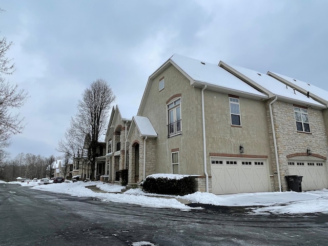 view of snow covered exterior with a garage