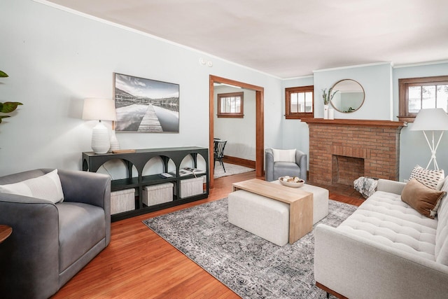 living room with hardwood / wood-style flooring, ornamental molding, and a fireplace