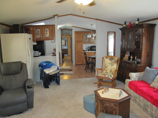 living room with ceiling fan, ornamental molding, lofted ceiling, and light hardwood / wood-style flooring