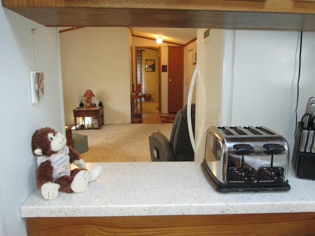 kitchen featuring carpet floors, light stone countertops, and lofted ceiling