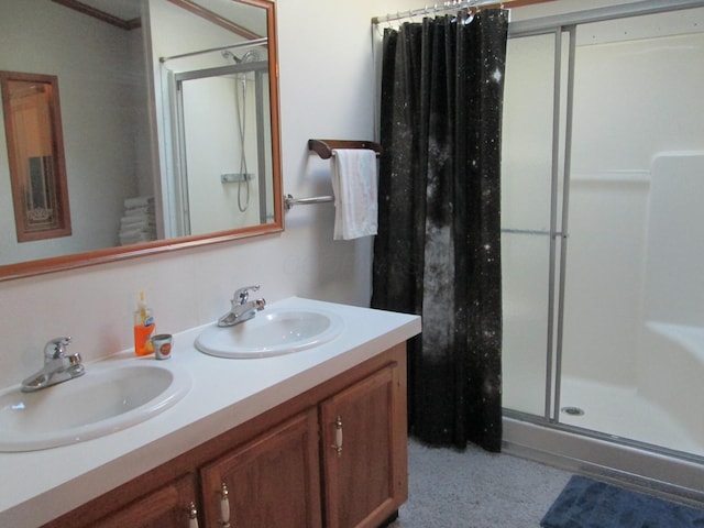 full bathroom featuring double vanity, a sink, and a shower stall