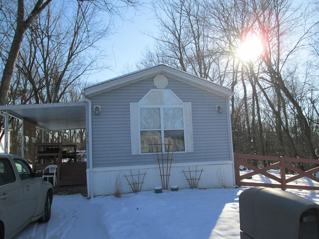 snow covered property featuring a carport