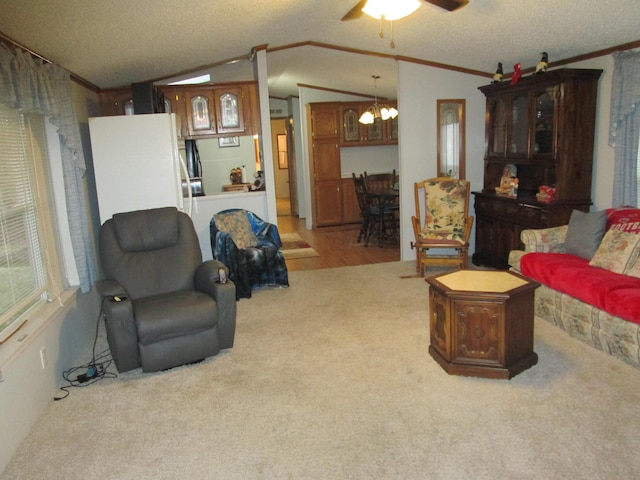 carpeted living room with vaulted ceiling, ornamental molding, a textured ceiling, and ceiling fan with notable chandelier