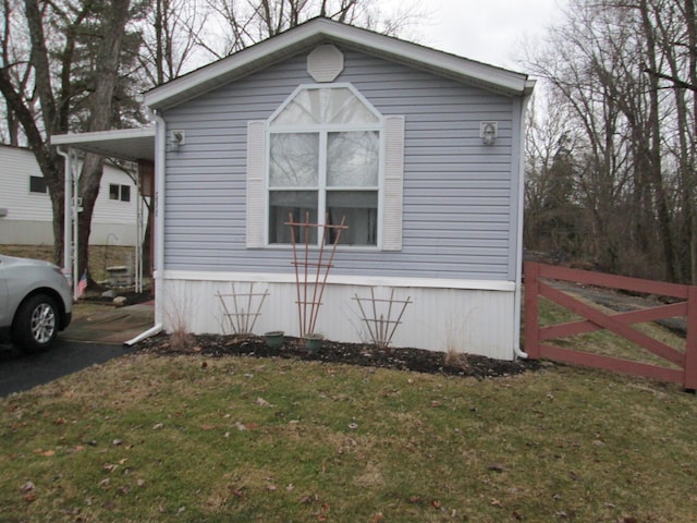 view of property exterior with fence and a lawn