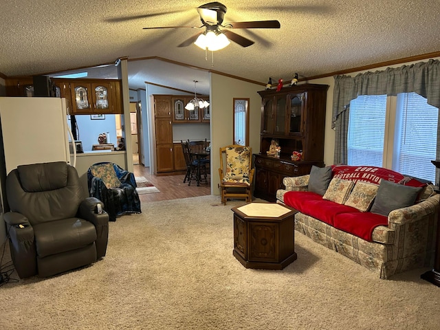 carpeted living room with lofted ceiling, ornamental molding, a textured ceiling, and ceiling fan with notable chandelier